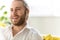 Photo of young businessman wearing white shirt and earpods in apartment