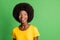 Photo of young charming pretty smiling excited dreamy afro girl looking copyspace isolated on green color background