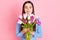 Photo of young charming sweet smiling lovely dreamy girl in dotted blouse smell flowers isolated on pink color