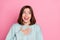 Photo of young cheerful girl hand on chest look empty space laughing humorous isolated over pink color background