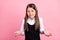 Photo of young clueless unhappy girl shrug shoulders wear uniform no idea isolated on pink color background
