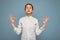 Photo of young concentrated pretty brunet lady with sincere emotions wearing white shirt isolated over blue background