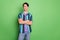 Photo of young confident dreamy man look empty space hold hands crossed isolated on green color background