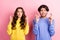 Photo of young couple worried nervous crossed fingers wish luck success isolated over pink color background