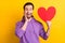 Photo of young excited man happy positive smile heart romantic feelings unexpected isolated over yellow color background