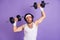 Photo of young funky funny crazy man in glasses lifting heavy dumbbell building muscles isolated on violet color