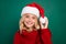 Photo of young girl happy positive smile hold santa hat ball costume party isolated over green color background