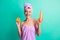 Photo of young girl hold orange shampoo bottle wear violet towel turban isolated teal color background