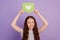 Photo of young girl hold reaction icon like above head isolated over purple background
