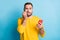 Photo of young handsome scared worried afraid man bite teeth hold smartphone isolated on blue color background