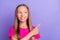 Photo of young happy dreamy small girl look point finger empty space sale advert isolated on violet color background