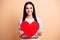 Photo of young happy lovely positive cheerful smiling girl hold big red heart  on beige color background