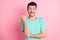 Photo of young happy positive cheerful excited crazy man pointing thumb in copyspace isolated on pink color background