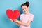 Photo of young happy positive cheerful girl hold hands red paper heart smile isolated on pastel blue color background