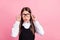 Photo of young happy positive small girl amazed shocked look empty space glasses isolated on pink color background