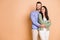 Photo of young happy positive smiling cheerful dreamy couple hug each other look copyspace isolated on beige color