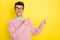 Photo of young happy smiling dreamy man in glasses point finger copyspace advertisement isolated on yellow color