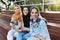 Photo of young islamic women wearing headscarfs sitting on bench in park