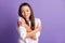 Photo of young lovely pretty dreamy cute sweet smiling girl embrace herself isolated on violet color background