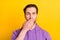 Photo of young man close cover mouth hand oops worried nervous fail isolated over yellow color background