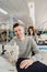 Photo of a young man and other seamstresses sewing with sewing machine in a factory