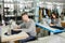 photo of a young man and other seamstresses sewing with sewing machine in a factory