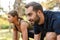 Photo of young pleased couple doing exercises while working out