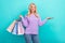 Photo of young positive attractive fashionista shopaholic woman wear knit purple jumper hold palm new manufacture