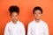Photo of young preteen african kids serious confident pupils school isolated over orange color background