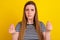 Photo of young pretty girl show fingers ask money cash symbol conflict isolated over yellow color background