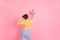 Photo of young pretty lovely funky funny careless girl painting walls with sprayer isolated on pink color background