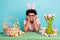 Photo of young satisfied dreamy attractive guy touch cheeks smiling desk easter spring holiday basket colored eggs