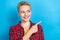 Photo of young satisfied short blonde hair girl wear plaid red shirt look point finger mockup opening cafe ad isolated