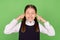 Photo of young school girl unhappy negative close cover ears annoyed loud  over green color background