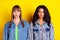 Photo of young serious beautiful stunning gorgeous girls best friends wear denim jacked isolated on yellow color