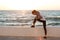 Photo of young slim sport woman tying shoelace at the seaside