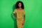 Photo of young smiling cheerful stunning african woman in yellow dotted dress isolated on green color background