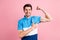 Photo of young smiling sportive strong male showing muscles recommend healthy life isolated on pink color background