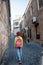 Photo of young tourist girl exploring streets of Baku. Redhead girl with backpack visiting old city