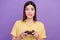 Photo of young woman afraid bite lips teeth play game station race speed lose isolated over violet color background