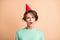 Photo of young woman astonished shocked displeased dislike surprise wear party hat isolated over beige color background