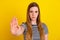 Photo of young woman serious show hand stop enough symbol forbidden isolated over yellow color background