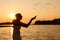 Photo of a young woman at sunset. Situ is a side view of a slender, beautiful blonde in a summer dress and a straw hat