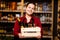 Photo of young woman with wooden box with bottles in her hands in wine shop