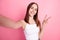Photo of youth lovely girl show fingers peace cool v-symbol make selfie influencer isolated over pink color background