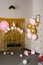 Photo zone for a little Princess: a carriage and balloons on a Golden shiny background. Decor for a child`s birthday