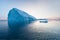 Photogenic and intricate iceberg under an interesting and blue sky during sunset. Effect of global warming in nature.