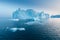 Photogenic and intricate iceberg under an interesting and blue sky during sunset. Effect of global warming in nature.