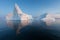 Photogenic and intricate iceberg under an interesting and blue sky during sunset. Effect of global warming in nature.