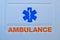 Photograph of ambulance car sign and text on white. The emergency services